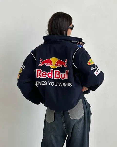 Model wearing oversized Red Bull Racing streetwear jacket with black jeans and white sneakers
